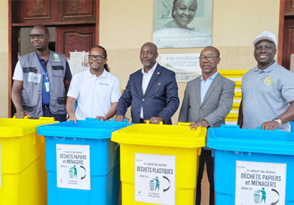 Intertek colleagues and local officials stand behind donated recycling bins. 