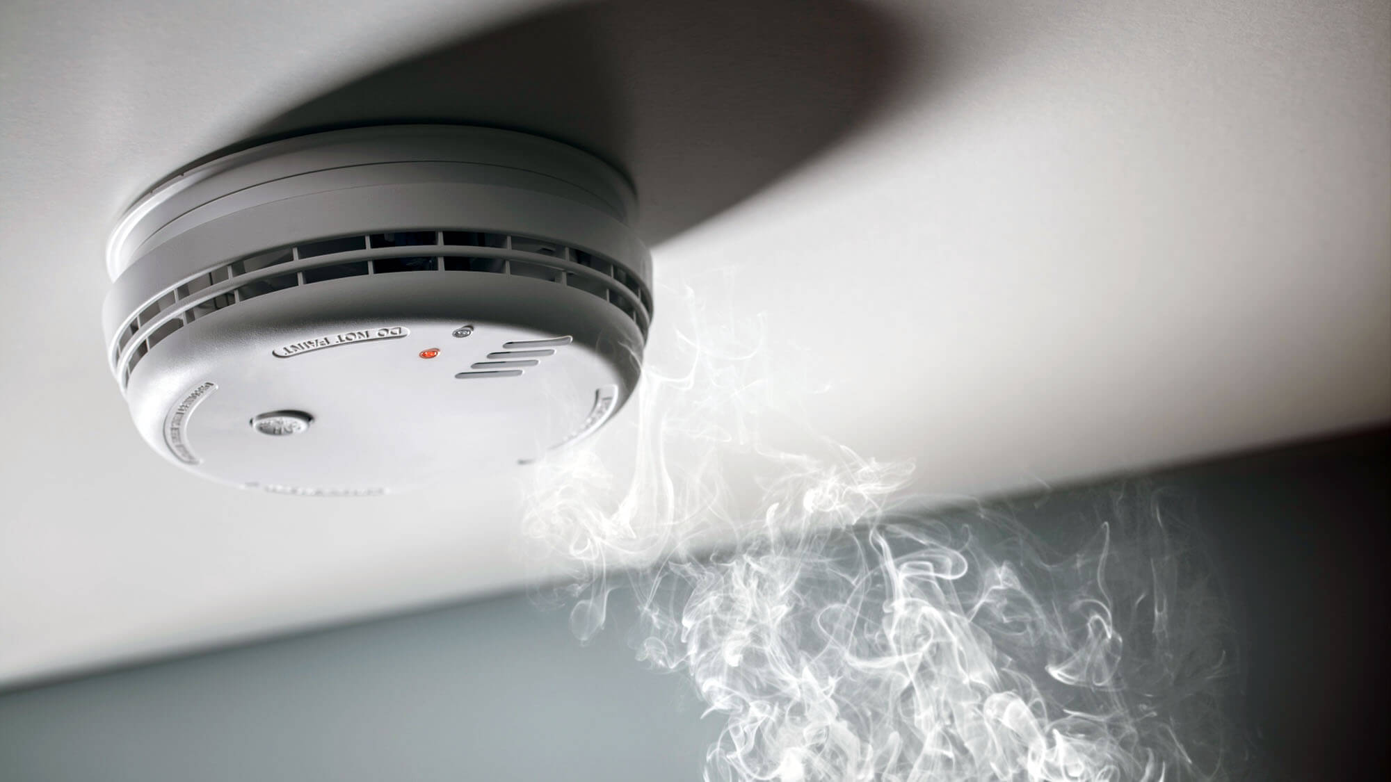 Smoke detector and interlinked fire alarm in action background