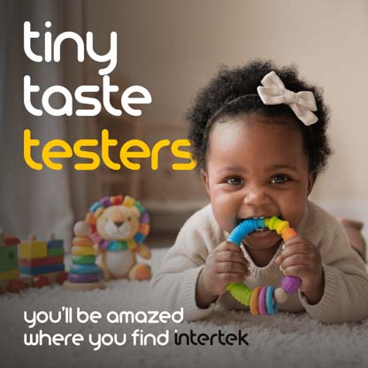 A smiling infant with a teething ring in her mouth