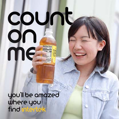 A woman smiling while holding a bottle of tea with the nutrition label displayed